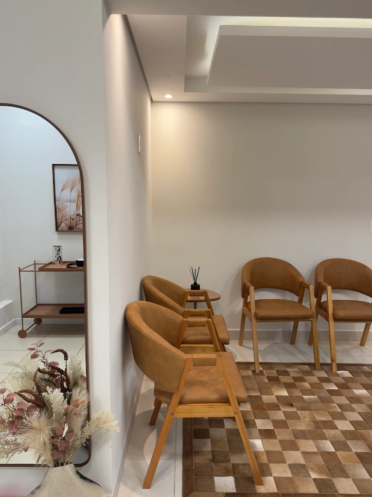 Sala de espera do consultório com poltronas, espelho e decoração em tons neutros